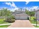 Charming exterior with a three-car garage, paver driveway, complemented by lush landscaping at 10703 Morning Dew Way, Tampa, FL 33647