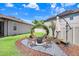 A cozy backyard fire pit surrounded by chairs and decorative landscaping, ideal for outdoor gatherings and relaxing evenings at 10703 Morning Dew Way, Tampa, FL 33647