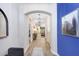 Elegant hallway featuring wood floors, a decorative archway, and stylish lighting fixtures at 10703 Morning Dew Way, Tampa, FL 33647