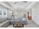 Bright living room with tray ceilings, modern chandelier, sectional sofa and decor at 10703 Morning Dew Way, Tampa, FL 33647