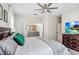Serene main bedroom with plush bedding, a ceiling fan, and an en-suite bathroom entrance at 10703 Morning Dew Way, Tampa, FL 33647