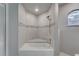 Modern shower and tub featuring an arched window and beautiful tile work at 11480 Genter Dr, Spring Hill, FL 34609