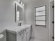 Contemporary bathroom featuring gray vanity, modern faucet, and natural light at 11480 Genter Dr, Spring Hill, FL 34609