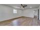 Spacious bedroom featuring wood-look flooring, a ceiling fan, and natural light at 11480 Genter Dr, Spring Hill, FL 34609