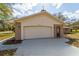 Charming garage with brick accents, lights, and ample parking space on the driveway at 11480 Genter Dr, Spring Hill, FL 34609