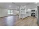 Open-concept kitchen featuring white cabinets, stainless steel appliances, and hardwood flooring at 11480 Genter Dr, Spring Hill, FL 34609