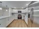 Well-appointed kitchen with white cabinetry, stainless steel appliances, and a breakfast bar with pendant lighting at 11480 Genter Dr, Spring Hill, FL 34609