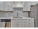 Close-up of a modern kitchen with sleek appliances, white cabinets, and mosaic backsplash, for culinary enthusiasts at 11480 Genter Dr, Spring Hill, FL 34609
