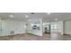 Open-concept living space with wood flooring, white walls, and views of the adjacent kitchen area at 11480 Genter Dr, Spring Hill, FL 34609