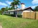 Ranch home exterior with mature landscaping and a newly installed fence at 12619 98Th St, Largo, FL 33773