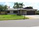 Charming single-story home with stone accents, lush lawn, and mature palm trees at 12619 98Th St, Largo, FL 33773