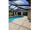 Inviting screened-in pool area featuring a refreshing pool and a spacious brick patio perfect for outdoor relaxation at 12619 98Th St, Largo, FL 33773