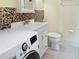 Bathroom featuring a modern washing machine, neutral tile, and bright vanity at 1325 58Th N St # 204A, St Petersburg, FL 33710