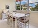 Bright dining room with large windows, white table and chairs, and tiled floor at 1325 58Th N St # 204A, St Petersburg, FL 33710