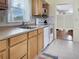 Traditional kitchen with tan countertop, white appliances, natural cabinets, and bright natural light at 1325 58Th N St # 204A, St Petersburg, FL 33710