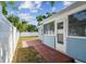 Charming backyard featuring a white fence, tiled patio, and lush greenery, offering privacy and outdoor enjoyment at 1724 W Saint Conrad St, Tampa, FL 33607