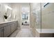 Bright main bathroom with double vanity, glass-enclosed shower, and access to main bedroom at 17909 Nadine Pl, Nokomis, FL 34275
