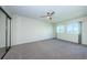 Well-lit bedroom features a ceiling fan, windows, and a spacious carpeted floor at 1805 Mariner Dr # 52, Tarpon Springs, FL 34689