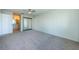 Carpeted bedroom leading into a bathroom with a mirrored closet and ceiling fan overhead at 1805 Mariner Dr # 52, Tarpon Springs, FL 34689