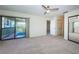 This light and airy bedroom features sliding glass doors to balcony, closet and neutral carpeting at 1805 Mariner Dr # 52, Tarpon Springs, FL 34689