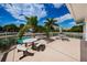A patio with picnic tables and a partial view of a pool surrounded by palm trees at 1805 Mariner Dr # 52, Tarpon Springs, FL 34689