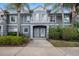 Inviting gray two-story condo featuring mature palm trees, manicured landscaping and a covered entry at 18111 Paradise Point Dr, Tampa, FL 33647