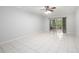 Bright living room features tile flooring, ceiling fan, and sliding glass doors to a screened-in patio at 18111 Paradise Point Dr, Tampa, FL 33647