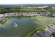 Beautiful aerial view of lakeside community with homes surrounding a picturesque lake and fountain at 20983 Monza Loop, Land O Lakes, FL 34638