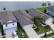 Aerial view of homes with well-maintained lawns, driveways, and a picturesque lake in the background at 20983 Monza Loop, Land O Lakes, FL 34638