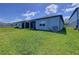 Spacious backyard with green lawn and a view of the home's exterior at 20983 Monza Loop, Land O Lakes, FL 34638