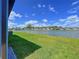 Scenic backyard view of the lake and lush green lawn extending to the water's edge at 20983 Monza Loop, Land O Lakes, FL 34638