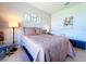 Cozy bedroom featuring a queen bed, stylish decor, and wood-look laminate flooring at 20983 Monza Loop, Land O Lakes, FL 34638