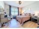 Bright bedroom with natural light, desk, chair, decorative ceiling fan, and view of the water at 20983 Monza Loop, Land O Lakes, FL 34638