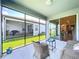 Covered lanai offering outdoor seating and views of the grassy yard and screened-in patio space at 20983 Monza Loop, Land O Lakes, FL 34638