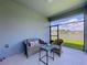 Relaxing screened lanai with wicker furniture and a serene view of the lake at 20983 Monza Loop, Land O Lakes, FL 34638