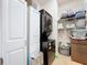 Efficient laundry room with stacked washer and dryer, storage cabinets, and shelving for organization at 20983 Monza Loop, Land O Lakes, FL 34638