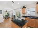 View of kitchen features dark granite countertops, a center island, and ample natural light from a bay window at 21840 Waverly Shores Ln, Land O Lakes, FL 34637