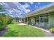 Well-manicured backyard featuring a covered patio with seating and ample green space at 22338 Bartholdi Cir, Land O Lakes, FL 34639