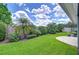 Picture-perfect backyard highlighting lush landscaping, including mature palm trees and verdant lawn at 22338 Bartholdi Cir, Land O Lakes, FL 34639