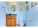Powder room featuring blue walls, wood vanity, and decorative mirror at 22338 Bartholdi Cir, Land O Lakes, FL 34639