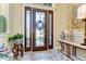 Welcoming foyer featuring a decorative front door with side lights, tile flooring, and accent table at 22338 Bartholdi Cir, Land O Lakes, FL 34639