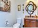 Stylish half bathroom featuring a decorative mirror, vessel sink, and unique artwork at 22338 Bartholdi Cir, Land O Lakes, FL 34639