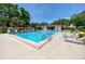 Community pool surrounded by lounge chairs and trees in a beautiful setting at 2363 Newburg Ln # B, Safety Harbor, FL 34695
