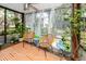 Bright sunroom with ceiling fan and sheer curtains and lounge furniture at 2363 Newburg Ln # B, Safety Harbor, FL 34695