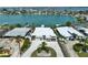 An aerial view captures this coastal home showcasing an elegant circular driveway and bay access at 25 Dolphin Dr, Treasure Island, FL 33706