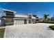 Stunning modern home with stone accents, a spacious driveway, and lush landscaping at 25 Dolphin Dr, Treasure Island, FL 33706