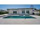 Luxury home featuring an outdoor pool with travertine deck and waterfront views at 25 Dolphin Dr, Treasure Island, FL 33706