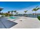 Inviting outdoor pool area with a travertine deck, waterfront access, and palm trees at 25 Dolphin Dr, Treasure Island, FL 33706
