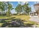 Large backyard with mature trees and a screened lanai offers ample space for outdoor activities at 25337 Durango Ct, Punta Gorda, FL 33955