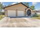 Close-up view of the single-story home with a three-car garage and screened entrance at 25337 Durango Ct, Punta Gorda, FL 33955